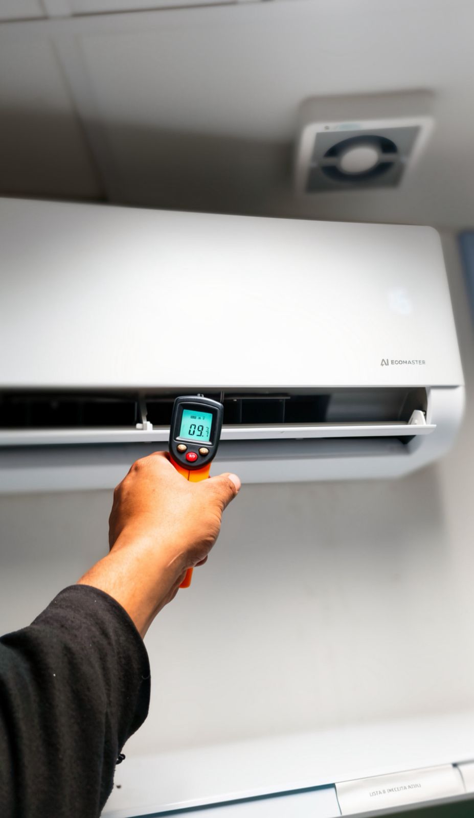 Medição de temperatura de um split com termômetro infravermelho durante manutenção